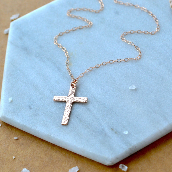 Rose gold cross necklace on a marble surface easter gift first communion