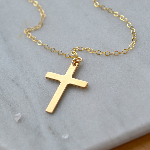 classic Gold cross necklace on a marble surface