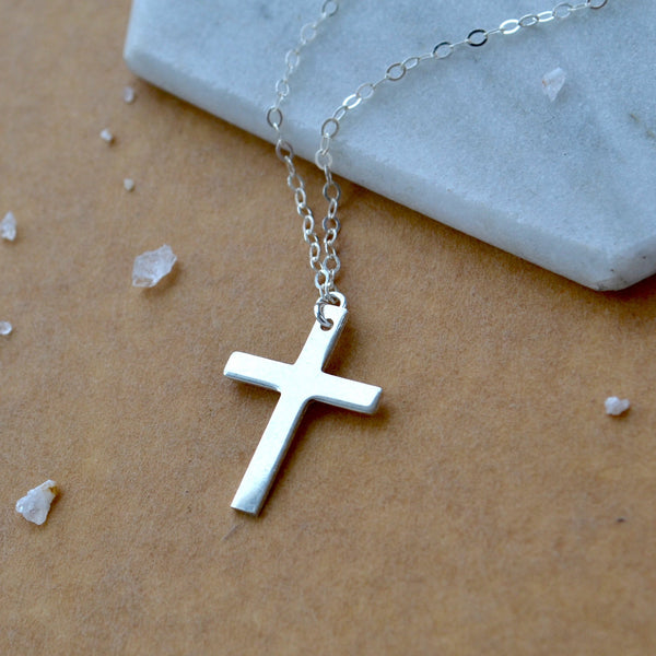 Classic Silver cross necklace on a marble surface